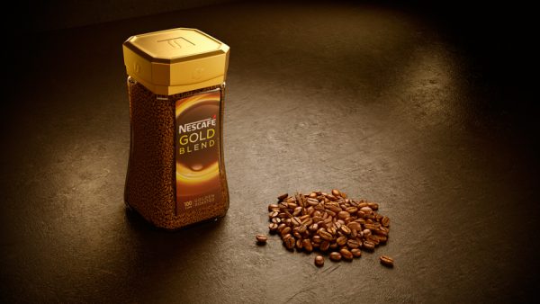 Nescafe gold blend with coffee beans in front cgi